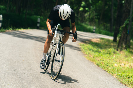Asian men are cycling road bike in the morning.He is on a forest road.の写真素材