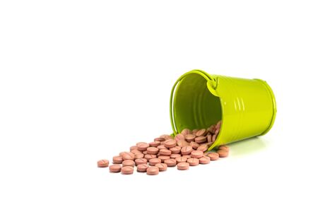 Pills, tablets in green metal bucket on white background.の写真素材