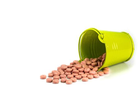 Pills, tablets in green metal bucket on white background.の写真素材