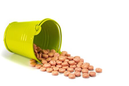 Pills, tablets in green metal bucket on white background.の写真素材