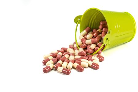 capsules in green metal bucket on white background.の写真素材