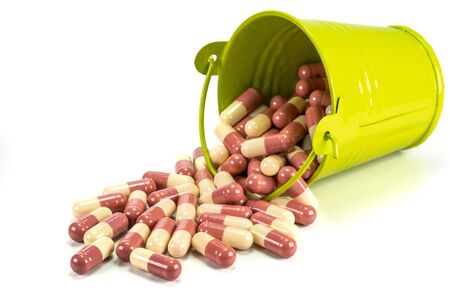 capsules in green metal bucket on white background.の写真素材