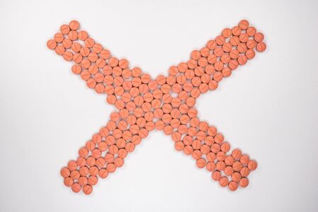 Orange colour round pills on white  background with selective focus. Pills that look like ecstasyの写真素材