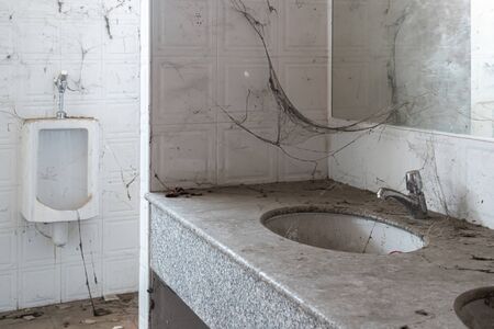 Abandoned toilet. a lot of cobwebs and garbage in abandoned toilet.の写真素材