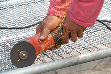man used angle grinder without cover guard cutting metal net to make bird cage.