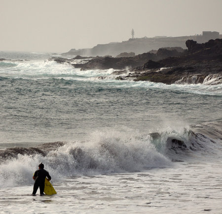 Surfer on the beach and coast with groundswell