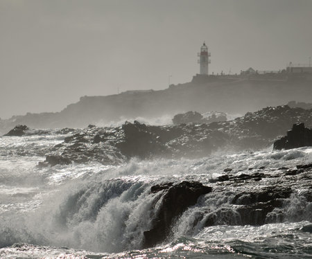 Waterfalls in the coast and lighthouse in background, La Garita, Gran Canariaの写真素材
