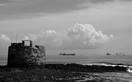 Old defense tower by the coast and ships in the bay, San Cristobal, Gran Canariaのeditorial素材