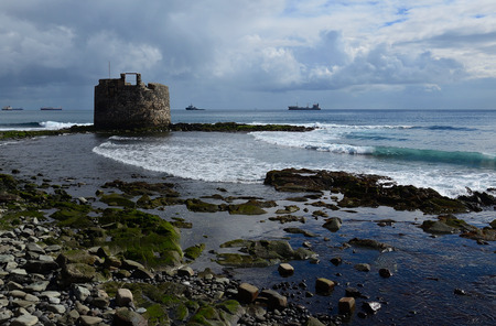 Coast at low tide and old defense tower by the sea, San Cristobal, Gran Canariaのeditorial素材
