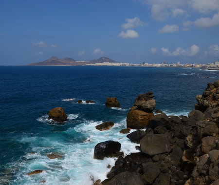 Coast of big rocks and city in the background, El Rincon, Las Palmas de Gran Canaria