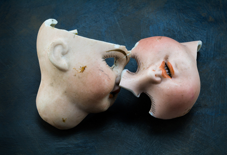 Broken vintage doll face parts on grunge backgroundの写真素材