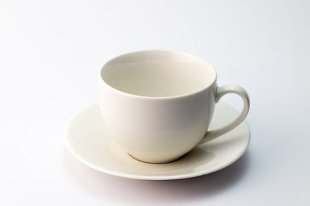 Empty white ceramic teacup and saucer isolated on white background