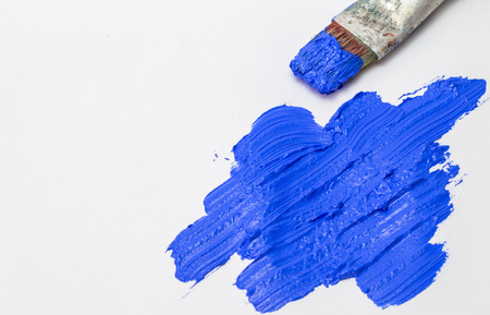 Abstract ultramarine blue brush stroke texture with old used paint brush on white backgroundの写真素材
