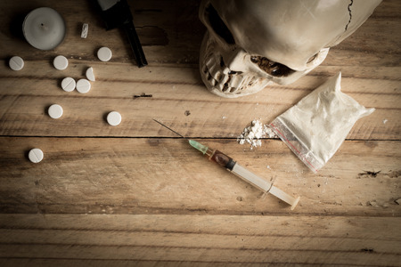 Drugs, powder, syringe and tablets on rustic wooden background. Drug addiction concept background with space for textの写真素材