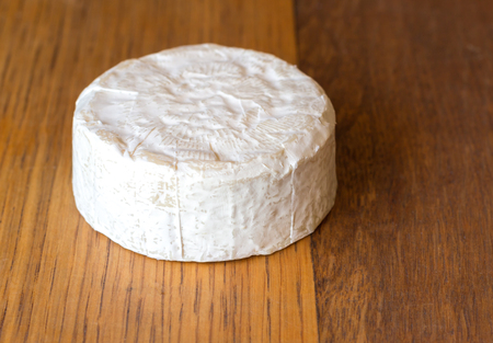 Camembert cheese round on oak wooden table close upの写真素材