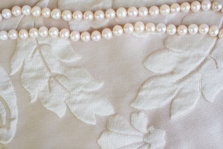 Pearl necklace on satin fabric texture background with space for textの写真素材