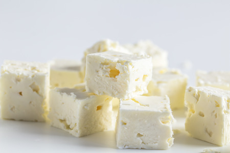 Feta cheese cubes isolated on white background with selective focusの写真素材