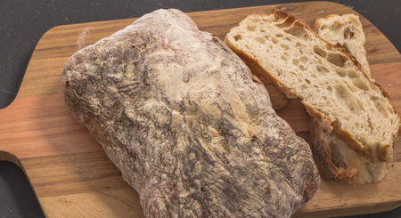 Bread and slices on wooden bread board - Selective focus on rustic bread close up