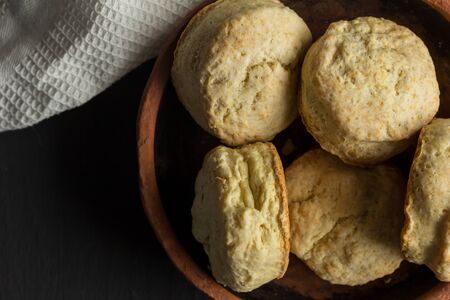 Buttermilk biscuits - scones in earthenware plate close up on black background - top view photographの写真素材