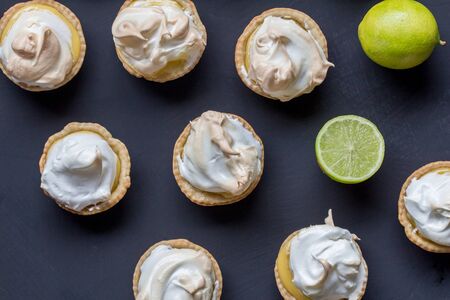 Lemon meringue tarts on black background - top view photo of limes and lime meringuesの写真素材