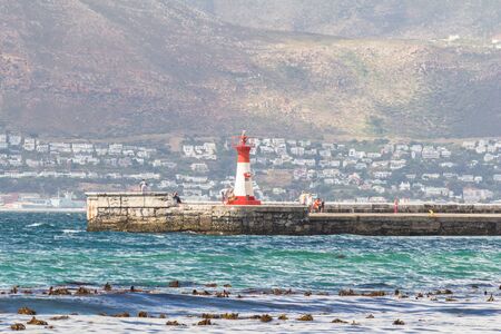CAPE TOWN , SOUTH AFRICA - 03 JANUARY 2019: View from St James beach over Kalk Bay recreational harbour and breakwater lighthouse built in 1919  in |False Bay, Cape Town South Africaのeditorial素材
