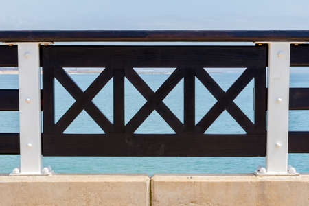 PORT ELIZABETH, SOUTH AFRICA - FEBRUARY 01 2020: Abstract close up view of handrail on balcony at Shark Rock Pier at Port Elizabeth beach - Close up of black and white balustradeのeditorial素材