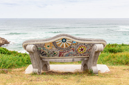 Empty bench with sea view - decorated bench with color mosaic tiles at Brenton on Sea, South Africaの写真素材