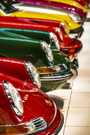 Display of colorful classic sports cars parked next to each other in an exhibit hallの写真素材