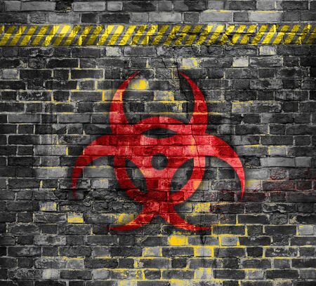 Old brick wall with bio hazard symbol painted on it.の写真素材