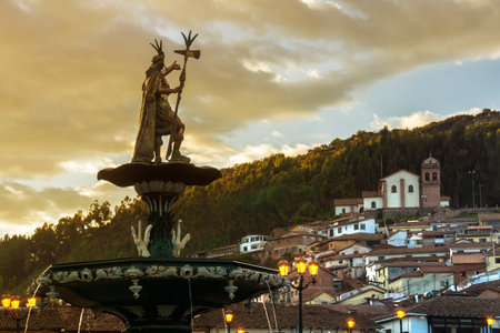 View of the fountain with San Cristobal church in the background. Plaza de Armas, Cusco, Peru, South...