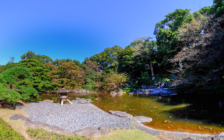A stone lantern by a pond in the shady Imperial Palace Gardens in Tokyo.のeditorial素材