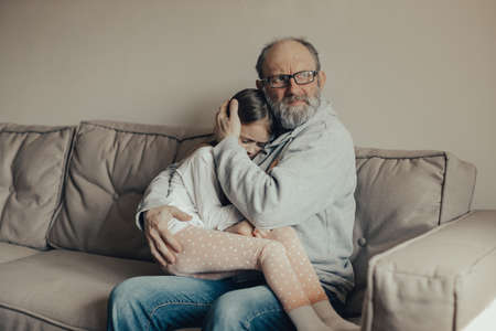 Ukrainian excited gray-haired man protects his little frightened granddaughter. Stop the war. Pray for Ukraine. We support Ukraine.の写真素材