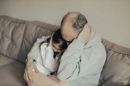 Ukrainian excited gray-haired man protects his little frightened granddaughter. Stop the war. Pray...