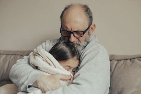 Ukrainian excited gray haired man protects his little frightened granddaughter. stop the war. Pray for Ukraine. We support Ukraine.の写真素材