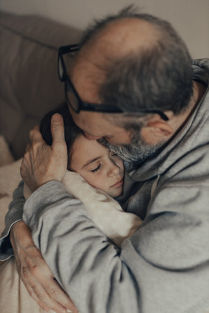 Ukrainian excited gray-haired man protects his little frightened granddaughter. stop the war. Pray...