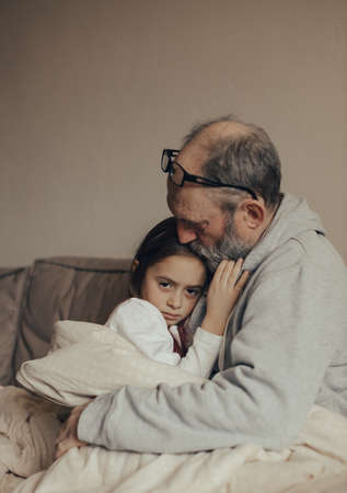 Ukrainian excited gray-haired man protects his little frightened granddaughter. stop the war. Pray for Ukraine. We support Ukraine.の写真素材