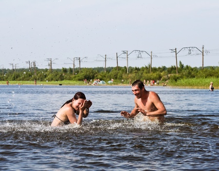  young people jump and splash around in the Lake の写真素材