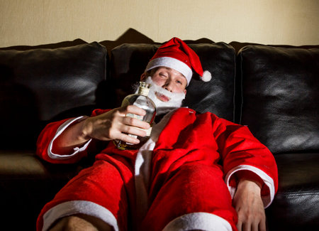 drunk Santa Claus posing with a bottle of whiskyの写真素材