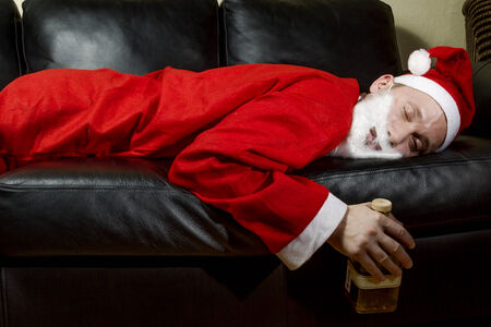 drunk Santa Claus posing with a bottle of whiskyの写真素材