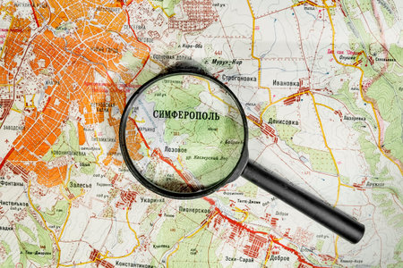 The city of Simferopol on map of Crimea through a magnifying glass, Ukraine