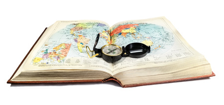 Compass lies on the terrain map, atlas book on white backgroundの写真素材