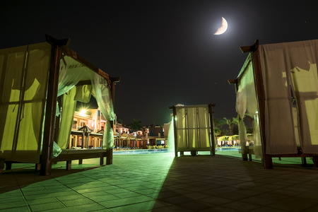 Beach bed with canopy by the pool on the beach at moonlightのeditorial素材