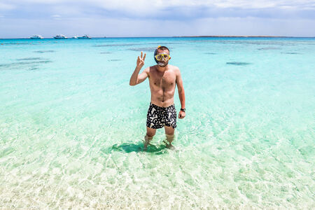 Man in the mask for posing against the backdrop of the beautiful sea landscape in sunny dayの写真素材
