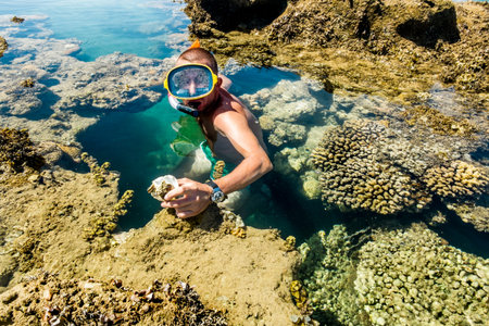 Man in the mask floats on a coral reef in the Red Sea, Egyptの写真素材