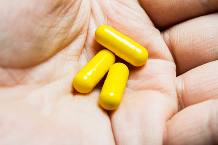 handful of yellow capsules lies in the Palm of your hand,macro