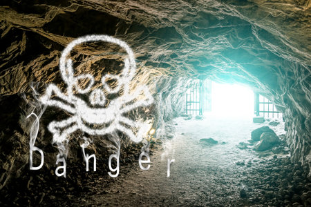 Skull with bones and inscription "danger" on the background of the tunnel in the caveの写真素材