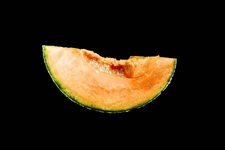 piece of succulent Orange melon are isolated on black backgroundの写真素材