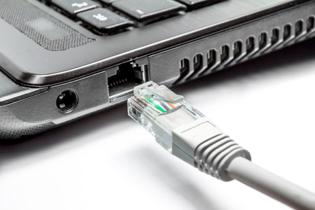 laptop with a network cable and plug on a white background