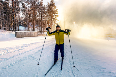 A skier posing on the slopes skiing in the woods at sunsetの写真素材