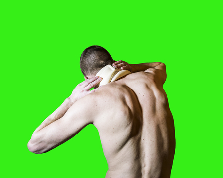 A man with a sore neck in the bus Trench is back isolated on green backgroundの写真素材